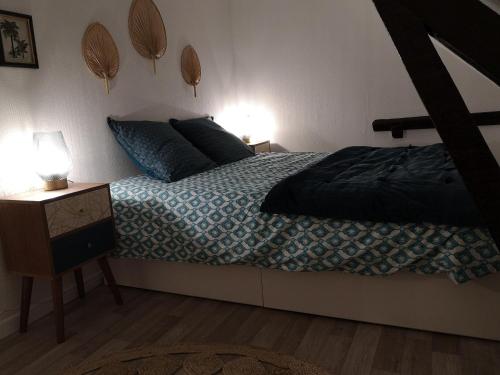 1 dormitorio con 1 cama y mesita de noche con 2 lámparas en Logement Cosy rénové au pied de la Cathédrale avec climatisation, en Reims