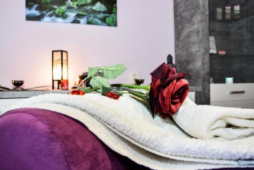 - une rose rouge sur une serviette blanche sur un lit dans l'établissement Hotel Waldblick, à Bodenmais
