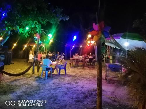 a group of people sitting at a table at night at Juara Ocean Chalet in Kampong Juara