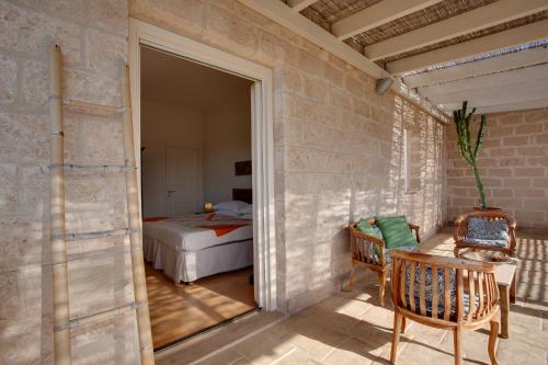 a room with a bedroom with a bed and a table at Geco Resort in Favignana