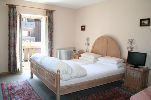 um quarto com uma cama grande e uma televisão em Haus Höllental em Garmisch-Partenkirchen