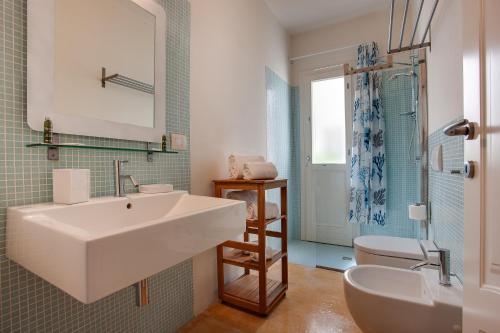 a bathroom with a white sink and a toilet at Geco Resort in Favignana
