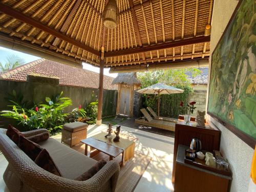 an outdoor living room with a couch and a table at Rumah Dadong in Ubud