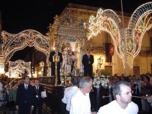 Un groupe de personnes debout dans une église aux lumières de Noël dans l'établissement B&B Mare di Augusta La Finestra sul Porto, à Augusta