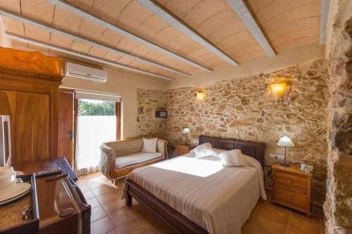 a bedroom with a bed and a chair in a room at Agroturismo Xarc in Santa Eularia des Riu