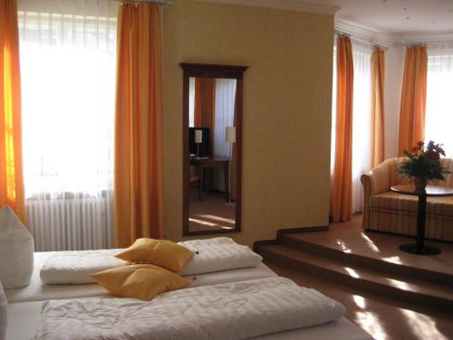 a bedroom with two beds and a large mirror at Altstadthotel Schex in Altötting