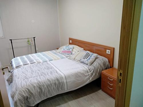 a bedroom with a bed and a wooden dresser at Albergue Barullo - Cubículos - Literas - Habitaciones in Sarria