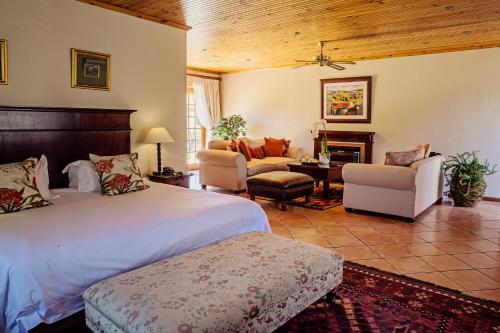 a bedroom with a bed and a living room at Oak Tree Lodge in Paarl