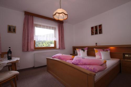 a bedroom with a bed with pink pillows on it at Landhaus Tschafein in Galtür