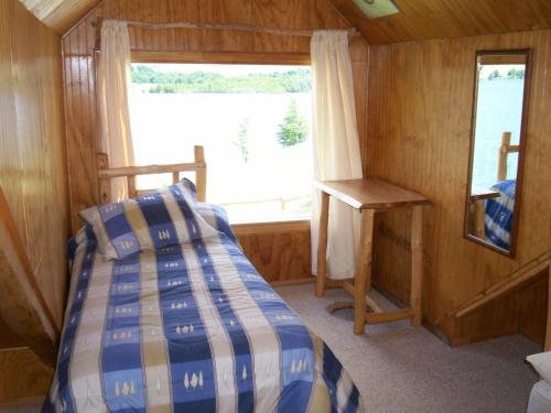 ein kleines Schlafzimmer mit einem Bett und einem Fenster in der Unterkunft Lodge de Montaña Lago Monreal in El Blanco