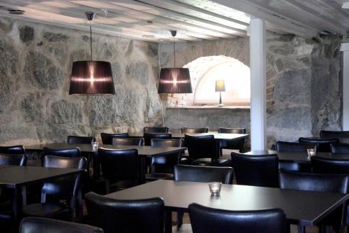 un restaurante con mesas y sillas y una pared de piedra en Gålö Havsbad - Holiday Cottages and Hostel, en Gålö
