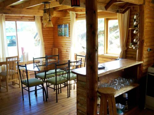 a dining room with a table and chairs in a cabin at Lodge de Montaña Lago Monreal in El Blanco