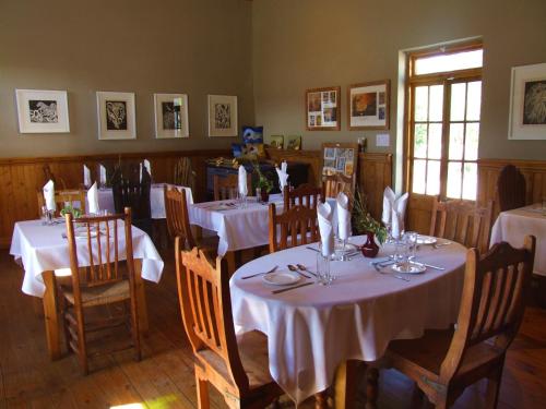 a dining room with tables with white tablecloths at Bethesda Tower Accommodation in Nieu-Bethesda