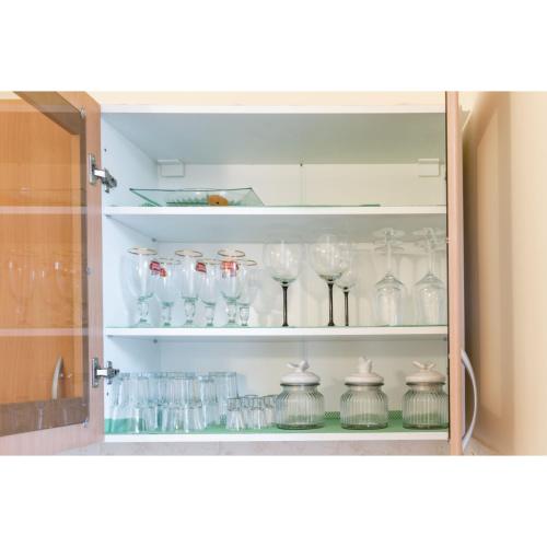 a cabinet filled with glasses and vases at Kata's Place in Subotica