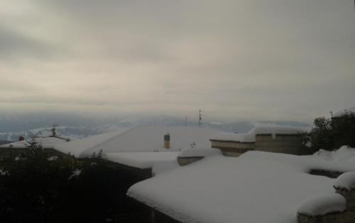 a snow covered roof of a house with snow at Osteria Della Posta in Poggio Picenze