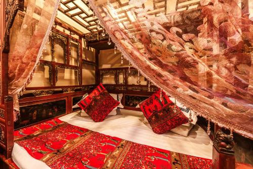 a bedroom with a canopy bed with red pillows at Pingyao Hongyuyuan Guesthouse in Pingyao