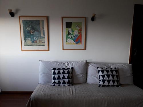 a bedroom with a bed with two pictures on the wall at Apartamento Fonte Luz in Matosinhos