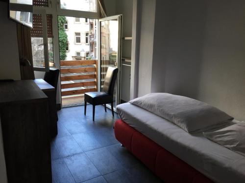 a bedroom with a bed and a desk and a window at Wasserturm Hotel Mannheim in Mannheim