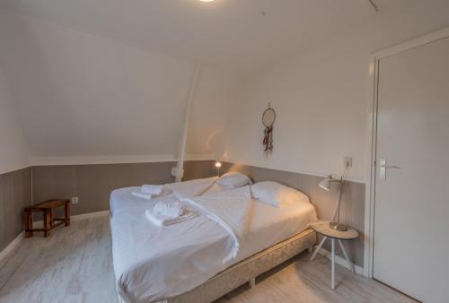 a bedroom with a bed with white sheets at Boutique Appartement-Hotel Villa Juttershof in Bergen