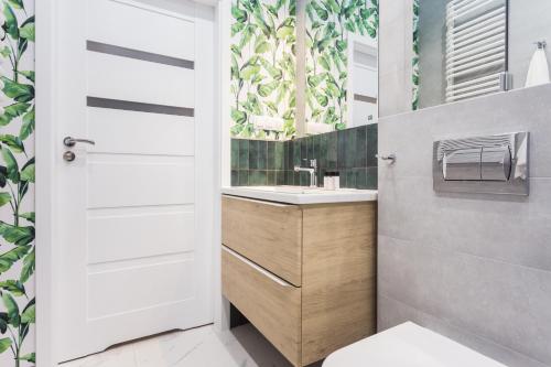 uma casa de banho com um lavatório e um WC em City of the Kings - Leaf Apartment em Cracóvia