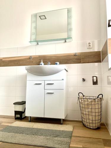 a bathroom with a white sink and a mirror at JP-KU ubytování Kadaň in Kadaň