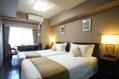 Un pat sau paturi într-o cameră la Le Tour Hotel Akihabara Ekimae 楽途ホテル秋葉原駅前店