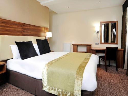 
سرير أو أسرّة في غرفة في فندق ميركيور لندن بلومزبري
