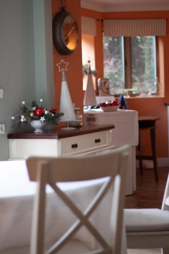 a kitchen with orange walls and a table with christmas decorations at American House Puławska in Warsaw