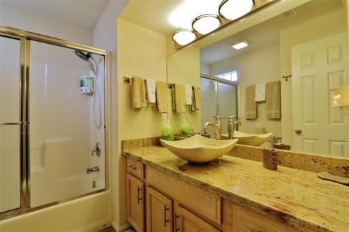 a bathroom with two sinks and a large mirror at South Padre Island Condo with Pool Access and Balcony! in South Padre Island