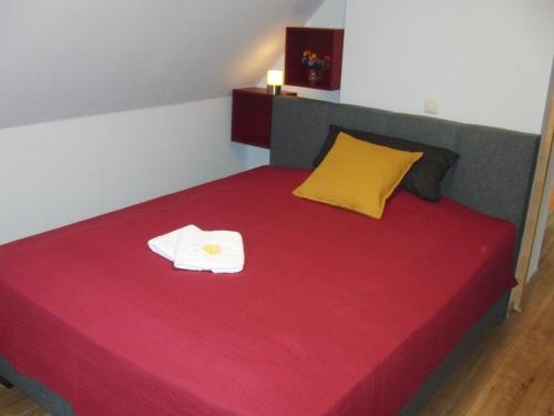 a bedroom with a red bed with two towels on it at Ferienhaus Grabenhansl in Stubenberg