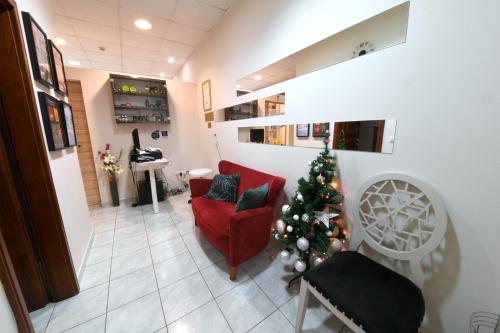a christmas tree in a living room with a red couch at Apartments & Rooms Krizevci in Križevci