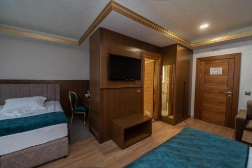 a hotel room with a bed and a flat screen tv at Hotel Park in Srebrenik