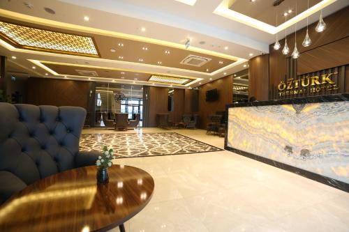um lobby de um hotel com uma mesa e uma televisão em EMA ÖZTÜRK THERMAL HOTEL em Afyonkarahisar