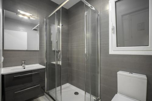 y baño con ducha, aseo y lavamanos. en Picasso - Local Rentss, en San Sebastián