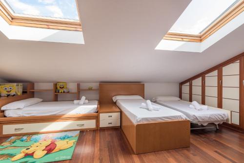 two beds in a room with skylights at Balea Dúplex - Local Rentss in Orio