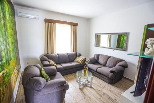 a living room with two couches and a television at Holiday Home Melone in Lećevica