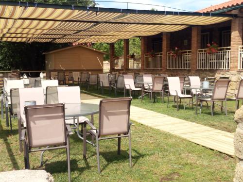 une table et des chaises sous une pergola en bois dans l'établissement casa rural buenos aires, à Acebo