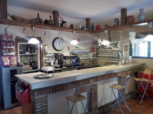 bar z dwoma krzesłami i zegarem na ścianie w obiekcie casa rural buenos aires w mieście Acebo