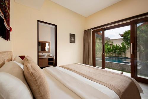 una camera con un letto e una grande finestra di Villa Apanya Sanur a Sanur