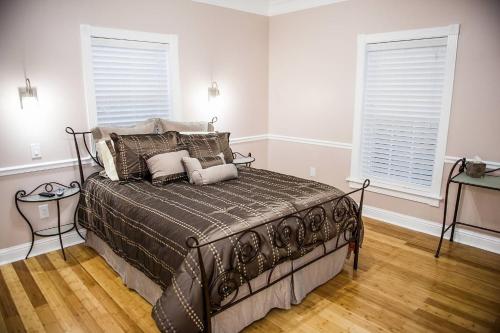 a bed in a bedroom with two windows at Villa with Waterfront Deck 23 Mi to Bourbon Street! in Venetian Isles