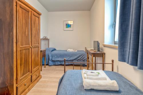 a small room with two beds and a cabinet at Agriturismo La Semente in Spello