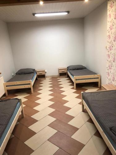 een kamer met drie bedden en een grote muur bij Apartament dla 4 osób in Dęblin