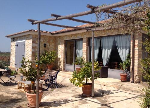 a brick house with a patio with potted plants at Villa Soleanda in Marsiliana