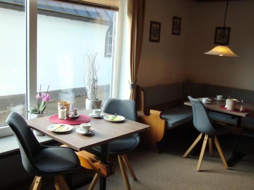 ein Esszimmer mit einem Tisch, Stühlen und einem Fenster in der Unterkunft Ferienwohnungen Weixler Schindelberg in Oberstaufen