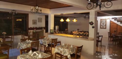un comedor con mesas y sillas en un restaurante en Hotel Villa Greenberg, en Monte Verde