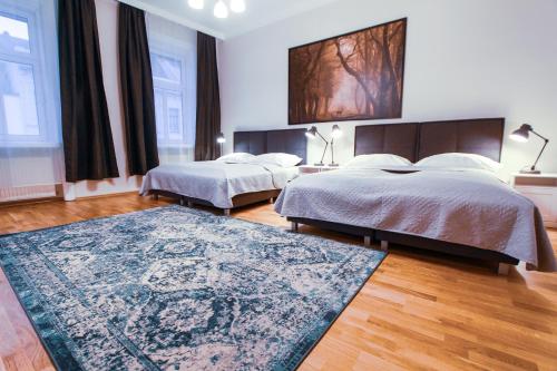 1 dormitorio con 2 camas y alfombra en Apartment Erdberg I contactless check-in en Viena