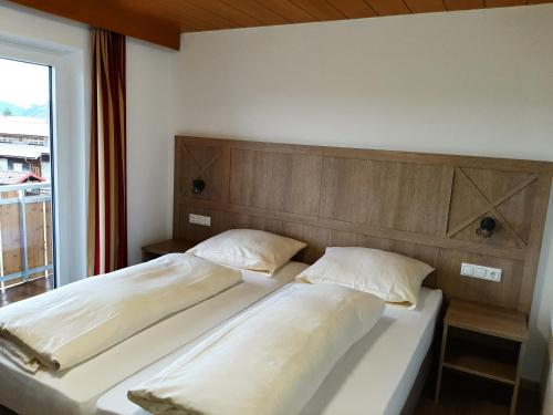2 Betten in einem Schlafzimmer mit einem großen Fenster in der Unterkunft Ferienwohnungen Weixler Schindelberg in Oberstaufen
