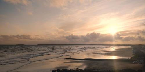 a view of the ocean with the sun setting at Avonmore House Guest Accommodation in Youghal