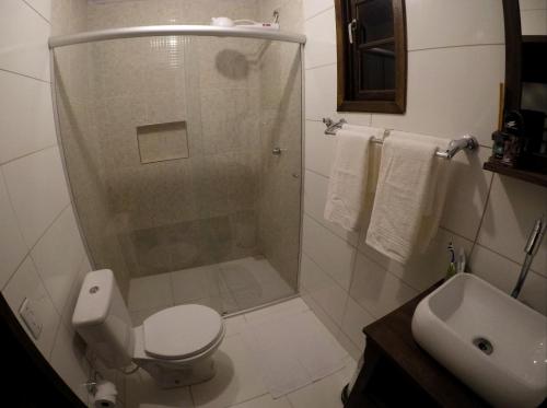 a bathroom with a shower and a toilet and a sink at Chalés da Longa in Angra dos Reis