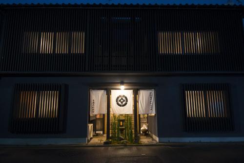 a building with a sign on the door at night at Nakamuraya Kyoto Enmachi Momiji in Kyoto